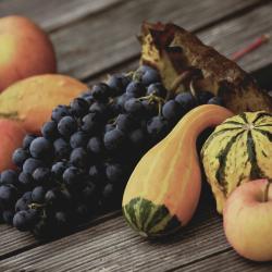 Obst, Gemüse und Wein auf einem Holzbrett