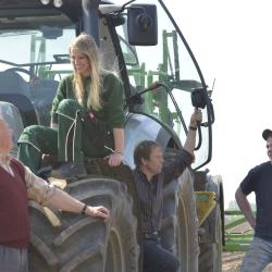 Ausbildung in der Landwirtschaft. Vier Personen stehen an einem Traktor. Von jung bis alt. 