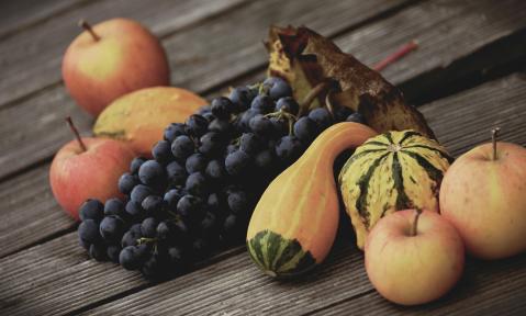 Obst, Gemüse und Wein auf einem Holzbrett