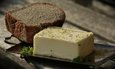 Butter mit Brot auf einem Tablett auf einem Holztisch